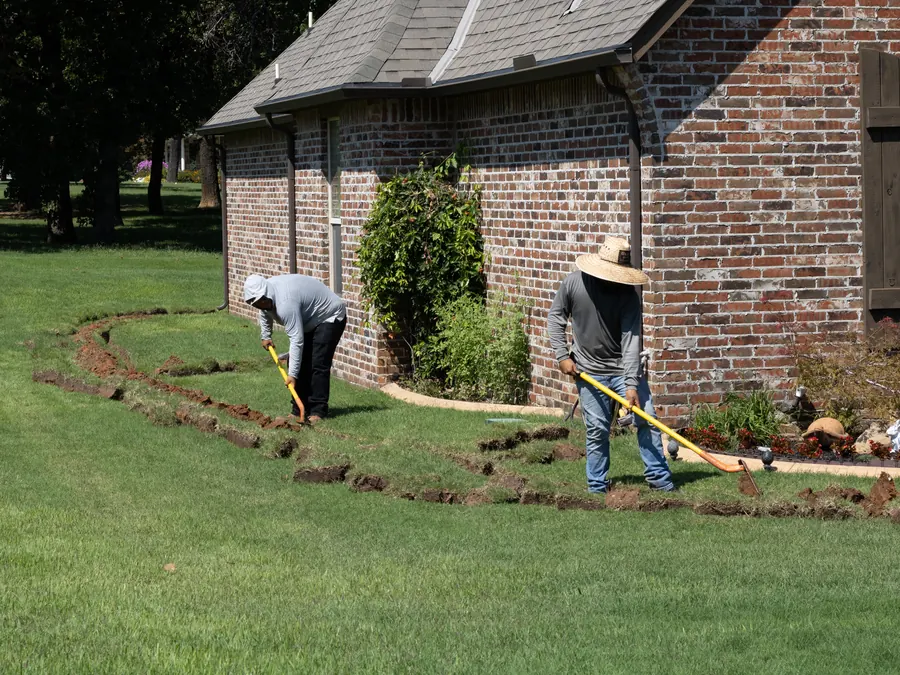 Crew digging a French drain in a front yard