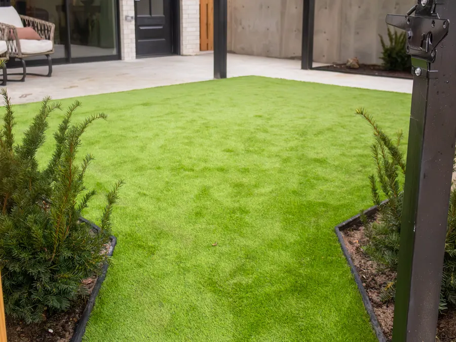 Backyard with new artificial turf and landscape borders